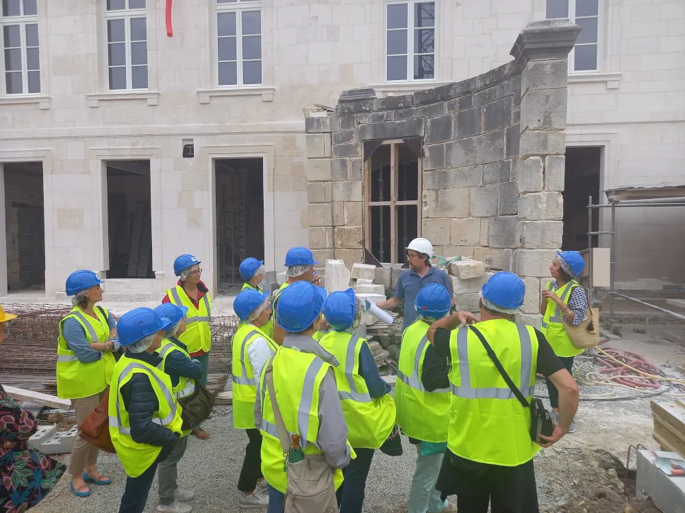 Visite d'un chantier, un groupe de personne avec casque et gilet de chantier
