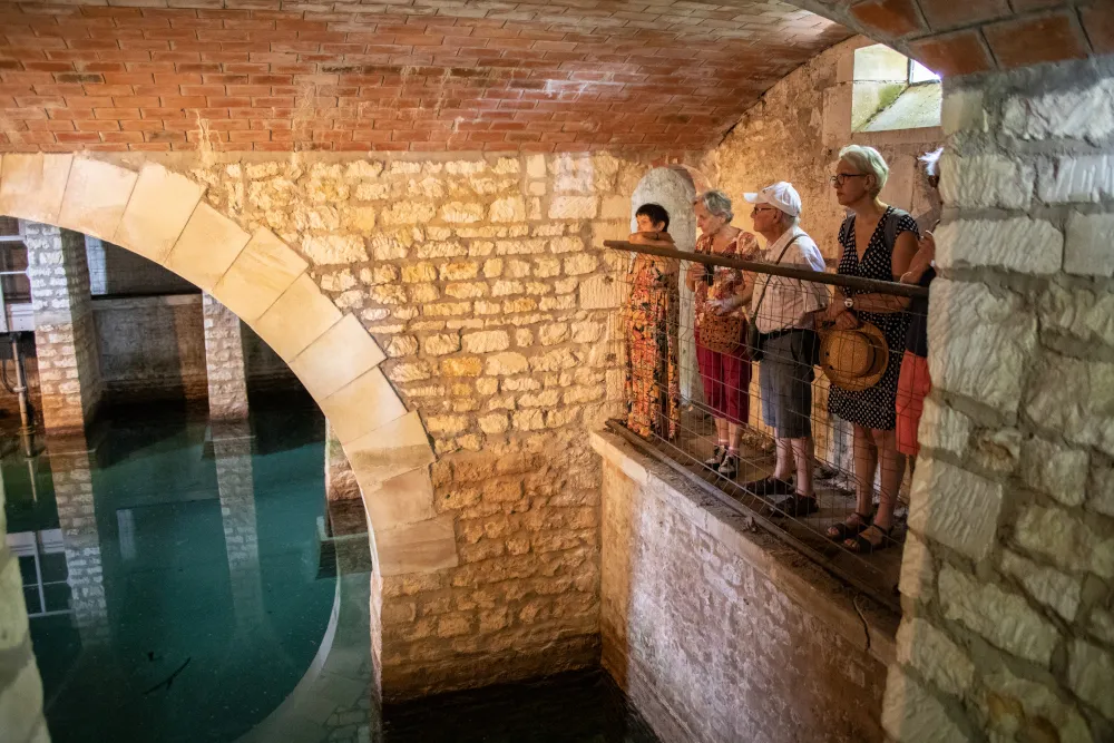 Un petit groupe de personnes face au bassin souterrain