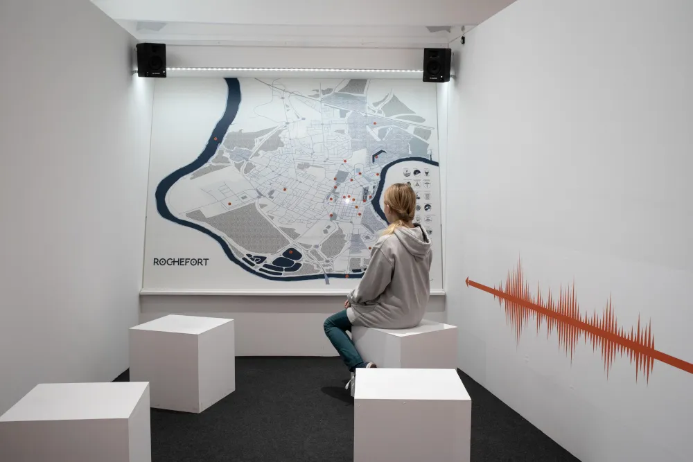 Personne de dos devant une carte de rochefort